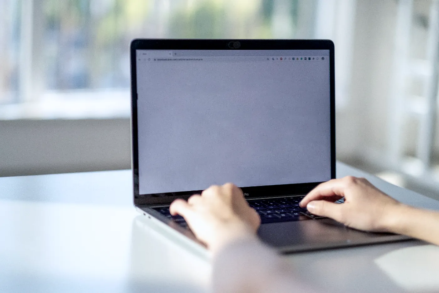 Des mains sur le clavier d'un ordinateur portable