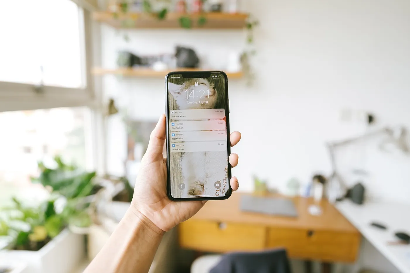 Une main tient un téléphone affichant une notification de message
