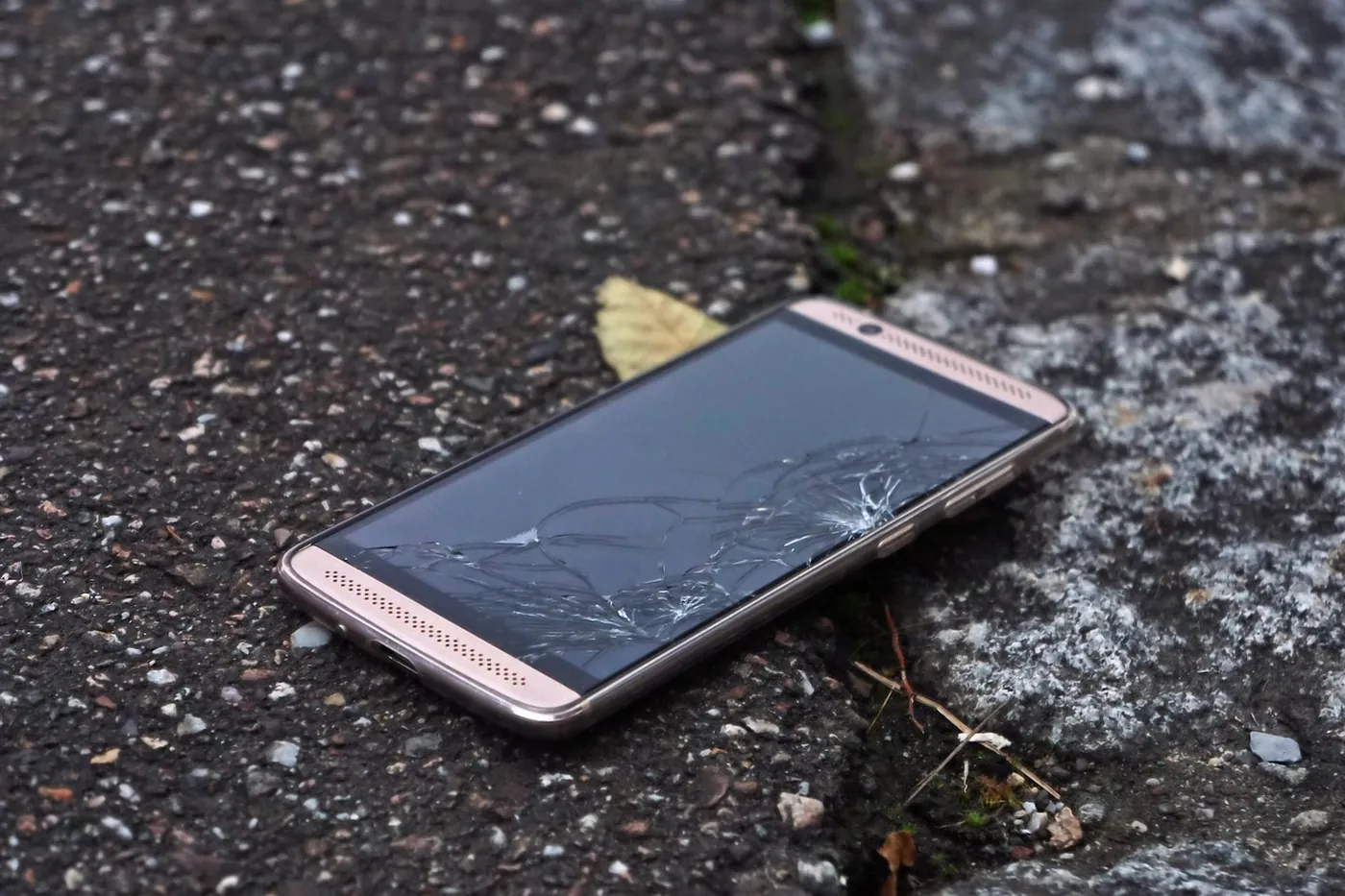 Un téléphone posé à plat, écran brisé