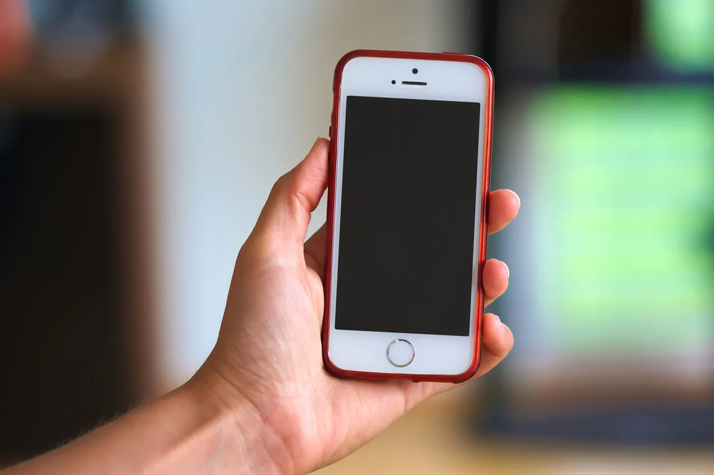 Une main tient un iPhone allumé