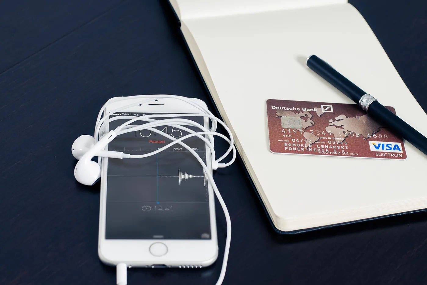 Une main tient un smartphone et une carte bancaire pour un paiement en ligne