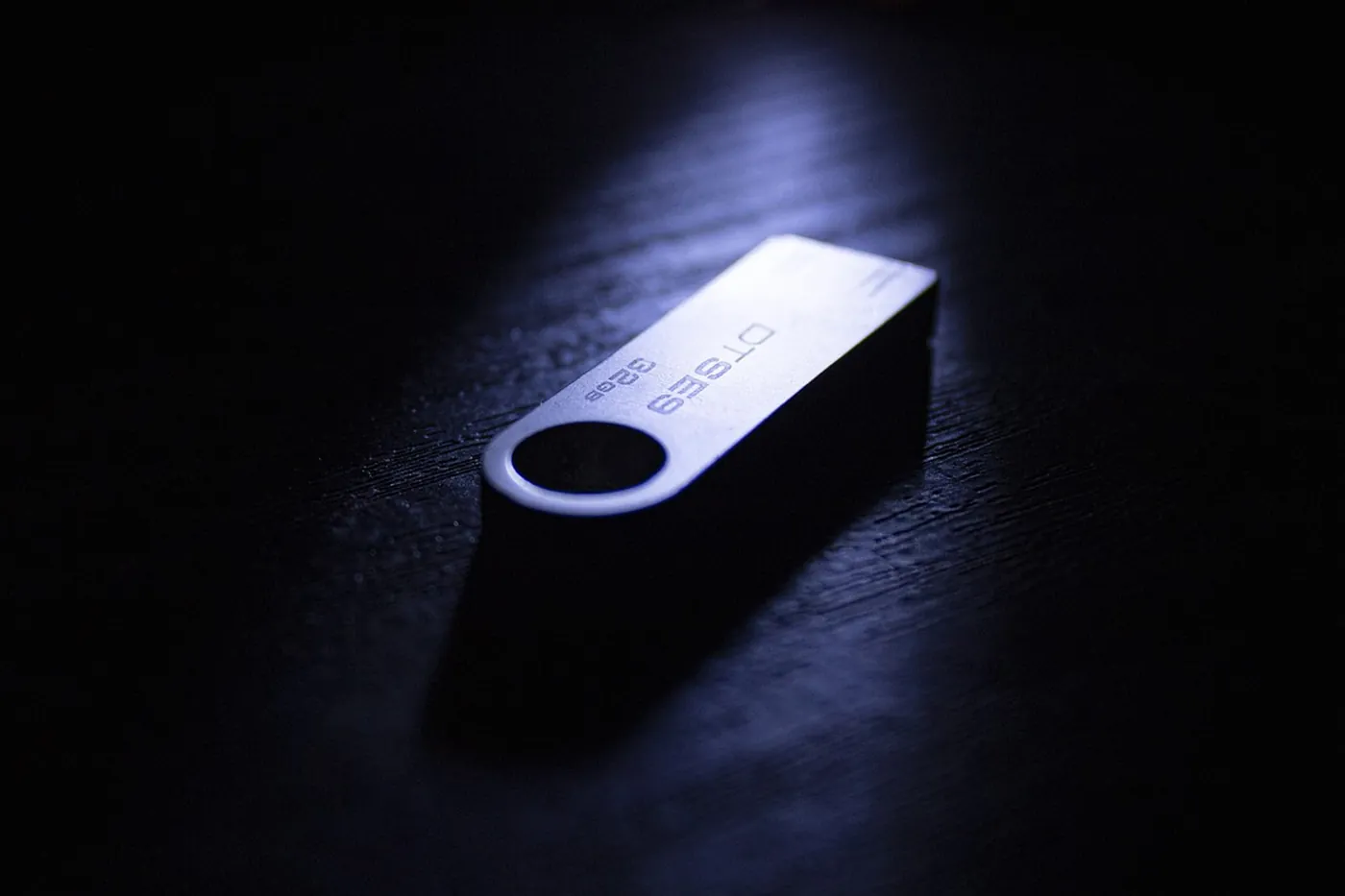 Une clé USB posée à côté d'un ordinateur