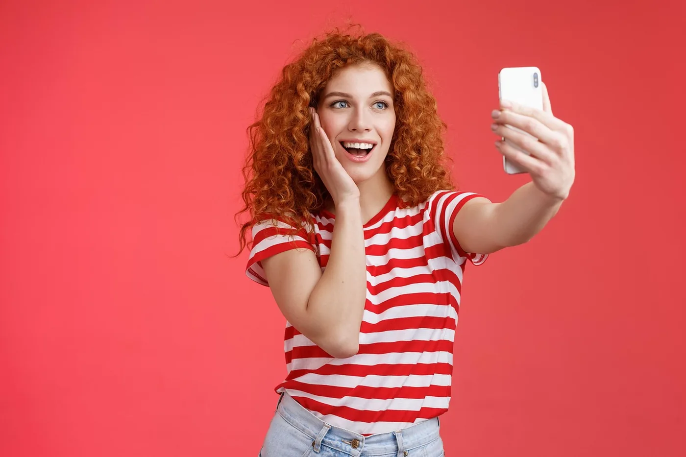Une jeune femme prend un selfie avec son smartphone