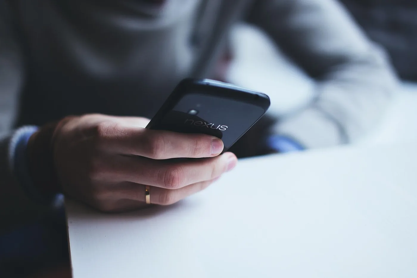 Une main tient un smartphone et écrit un message